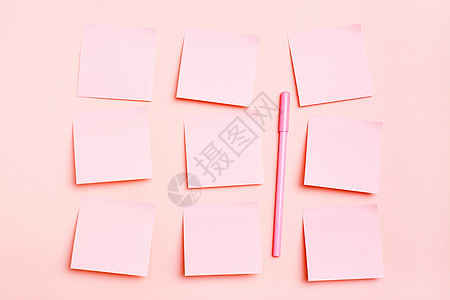 概念是粉红色的 空平方形的小纸页 以连行和笔写在粉红色背景上 顶部视图图片