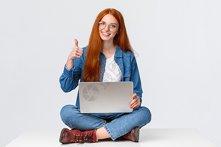 教育 互联网和人们的观念 女性红发数字游牧者 戴眼镜的自由职业女孩 在截止日期前完成项目 双腿交叉坐在地板上 拿着笔记本电脑 竖图片