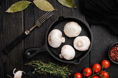 黑木桌底面的新鲜白圆冠香蘑菇图片