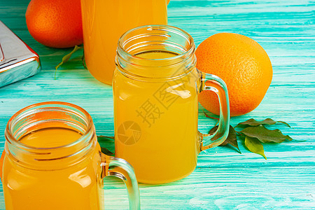 绿色木制桌上有橙汁的玻璃杯饮食水果乡村橙子桌子玻璃木头饮料早餐黄色图片