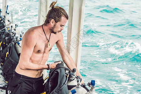 Diver准备在海上潜水的装备 并准备潜水设备调节器游泳气体控制旅行潜水员男人假期压力活动图片