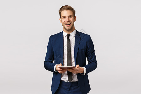 穿着经典西装打领带 开朗 优雅 留着胡子的商务人士 拿着数字平板电脑 热情地笑着 有商业计划书 站在白色背景上准备演讲背景图片