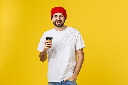 男人穿着孤立的鲜艳黄色 用外卖纸杯喝咖啡 微笑着 因为他会很好地开始新的一天杯子胡须饮料拉丁食物工作室男性咖啡店巧克力成人图片