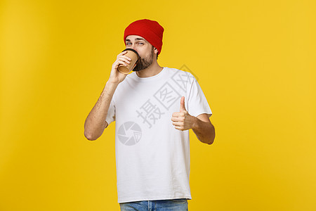 男人穿着孤立的鲜艳黄色 用外卖纸杯喝咖啡 微笑着 因为他会很好地开始新的一天工作室食物巧克力拉丁成人咖啡店杯子男性饮料胡须图片