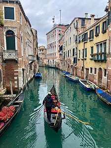 贡多利尔沿着威尼斯的一条运河行走图片
