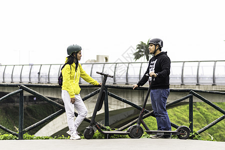 两个笑笑的朋友 戴着头盔自行车女孩滑板车生态道路车辆摩托车环保女性安全图片
