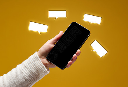 女性手持智能手机 黄色背景上空白黑屏的白黑屏幕成人气球消息电话商业社会女士聊天技术演讲图片