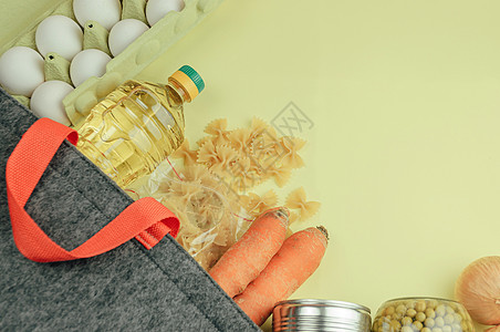 亚麻布袋中的食物捐赠 用生态袋 罐头食品 意大利面 豌豆 饼干 鸡蛋 黄油运送食物 带食品供应的生态袋 从上面看 捐赠和怜悯的概图片