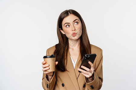 女销售员的肖像 公司妇女喝咖啡和阅读智能手机 看移动电话 白色背景等企业妇女的身影游民商务网络女性细胞工作商业成功管理人员工人图片
