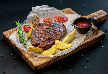牛肉牛排和木制桌上的西红柿和土豆产品香料美食菜单烧烤食物餐厅奶牛牛肉木板图片