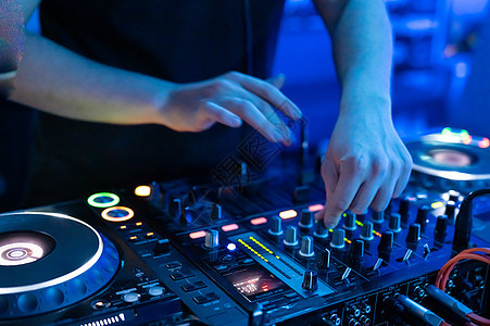 在夜总会迪斯科党的Dj Mixer主计长办公室 DJ手触摸按钮和幻灯片播放电子音乐音乐会展示混合器夜店舞蹈派对技术控制俱乐部光盘图片
