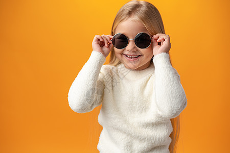 穿黄色背面墨镜的小姑娘 戴着太阳眼镜假期童年孩子微笑手势眼镜情感女性太阳镜乐趣图片