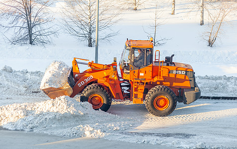 清扫和清理城市道路 以摆脱冬季的积雪工作机器卡车橙子行动街道挖掘机打扫服务雪堆图片