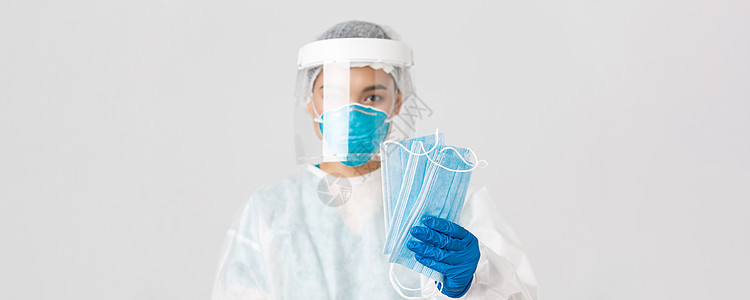 Covid19 冠状病毒病 医护人员的概念 身着个人防护装备的亚洲女医生特写为患者提供医用口罩以确保安全 白色背景暴发药品临床面图片