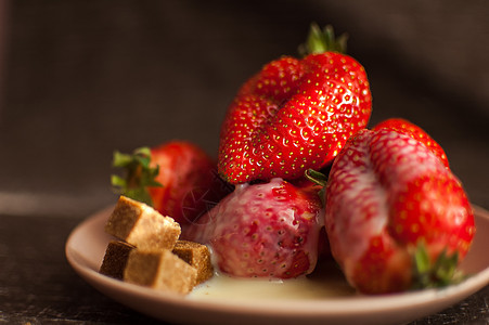 圆盘上红色成熟的草莓 配有几块甘蔗糖和融化的白巧克力烹饪营养浆果早餐乡村食物水果桌子美味甜点图片