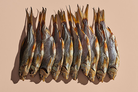 大量的干盐或烤咸蟑螂 粉红背景的可口小鱼 著名的啤酒点心 传统保存鱼类的方式 特写图片
