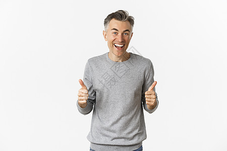 令人惊讶和快乐的中年人的画面 展示着拇指举起微笑 站在白色背景上促销灰色幸福中年商业工作室男性胡须发型广告图片