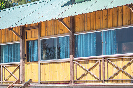 外景立面 木黄棕色板材 乡间别墅 全景玻璃窗自然反射 里面的窗帘 夏日温暖轻盈的心情 舒适的家庭内饰 休闲 生态建筑小屋木材风化图片