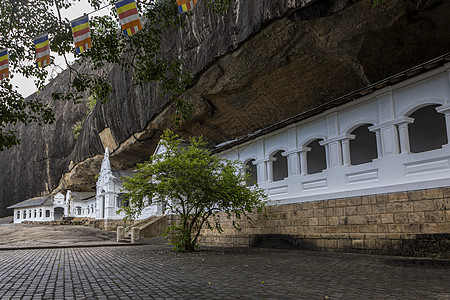 斯里兰卡 达姆布拉洞穴寺 外观全景和旗帜吸引力历史性精神旅游目的地结构石头历史洞穴地标图片