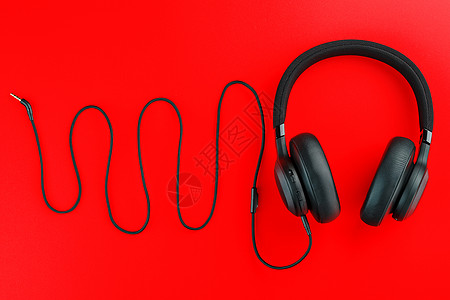 红背景的hi-fi耳机 以波音波为形式的铁丝网 从耳机线发出的声音频率图片