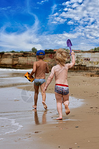 两个小男孩在海边玩弄游戏孩子娱乐兄弟海滩童年家庭太阳男生闲暇活动图片