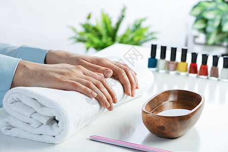 女性双手躺在白毛巾上美容院客户水疗手指瓶子指甲指甲油顾客护理温泉图片