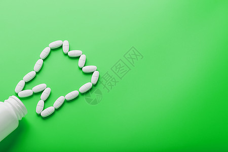在绿色背景的白色罐子上洒出的牙齿 以维生素钙的形式呈现出来抗抑郁药药丸化学品医生治疗丸药疾病银行药品剂量图片