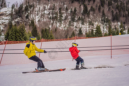 教官教男孩滑雪运动员在滑雪电梯上使用缆车运动旅行学习孩子家庭季节学校讲师父亲图片