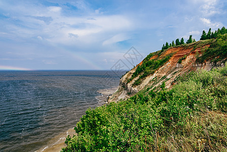 河岸上的悬崖蓝色日光荒野海岸支撑旅行叶子岩石林地彩虹图片