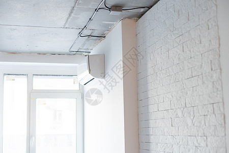 新安装的白色空调的镜头 工作 AC 挂在柔和的颜色墙上 有很多文本复制空间 背景图片