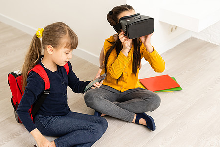 两个女孩在头盔虚拟现实中 儿童教育的生活方式概念 小儿科图片