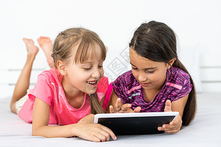 人 孩子 技术 朋友和友谊的概念在家寻找平板电脑的女孩房间乐趣青春期药片女学生互联网快乐女性女士朋友们图片