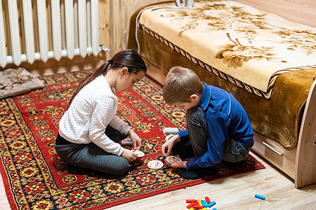 儿童在地板上玩砖头     关注男孩的脸孩子乐趣游戏玩具男生喜悦地面婴儿活动教育图片