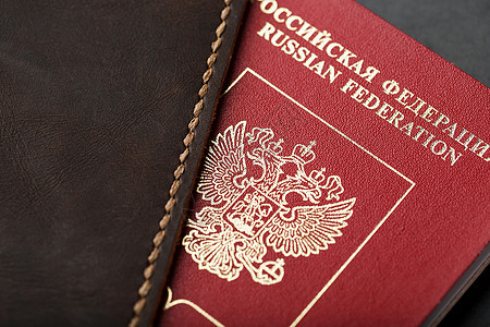 黑色背景带红色护照的棕色皮革封面国籍国家安全卡片部门假期插图公民旅游文档背景图片