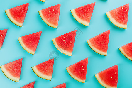 蓝色背景上红黄西瓜和红黄西瓜的新鲜片状图案墙纸热带食物甜点海滩潮人异国水果情调饮食图片