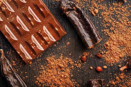 黑底的卡罗布巧克力棒豆子 甜食 巧克力和胡萝卜果糖做的甜食美食面粉甜点食物香料异国可可粉末烹饪地面图片