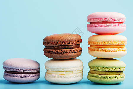 多彩的法国通心粉通心粉饼干 被安排在金字塔里 在蓝色背景上饼干小吃糕点味道奶油蛋糕面包酥皮风格紫色图片