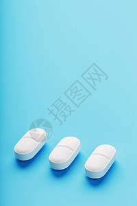 连续三片药片 在蓝色背景上 隔离治愈剂量疾病帮助治疗药店宏观处方抗生素胶囊图片