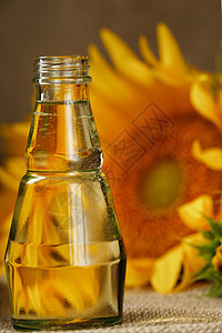 玻璃瓶里的向日葵油 还有木制背景的鲜花 特写粮食瓶子生物产品摄影蔬菜金子敷料作品养分图片