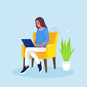 快乐的女人坐在扶手椅上 在笔记本电脑上工作 自由职业者 在线学习 在家工作 合作空间概念图片