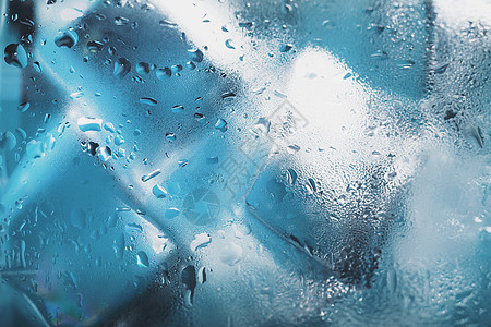 玻璃中的冰立方体 蓝色背景上有晶晶清水 Soft 选择性焦点气泡食物水晶流动调子飞溅瓶子运动苏打液体图片