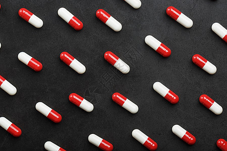一种黑色背景的红色和白色药丸模式 以黑本为例抗生素宏观药片健康胶囊药店保健化学卫生处方图片