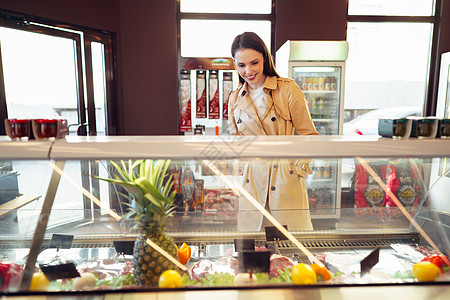 女性顾客反对食品店的原肉摊档部分快乐家庭冰箱食物营养商品检查货架购物市场图片