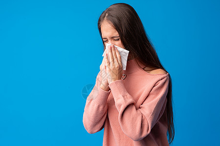 女孩在蓝背景下打鼻涕疾病盒子女性白色组织鼻子流感喷嚏过敏青少年图片