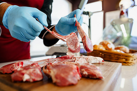 附近的屠夫 在屠宰场里放生羊排牛肉柜台食物男人标志商业肋骨木板围裙羊肉图片