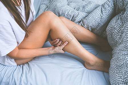 女人躺在床上 腿部肌肉痉挛 睡觉时肌肉痛或腿痛图片
