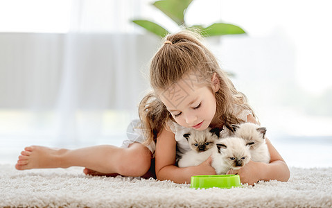 女孩有小猫的破布娃娃幸福友谊喂养哺乳动物快乐眼睛布娃娃动物猫咪童年图片