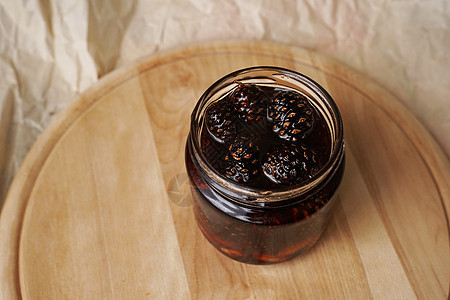 在木板上一个罐子里 生态友好 健康的松果酱玻璃锥体植物蜂蜜治疗食谱香气厨房咳嗽美食图片