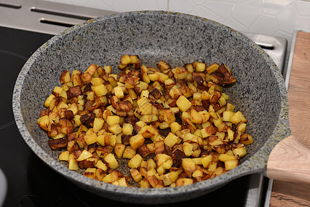 在一个旧金属煎锅上烤土豆罐头做自制的土豆锅里煮炸土豆薯片图片