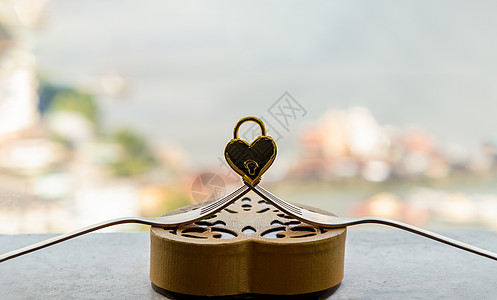 金色心形爱情挂锁在金色心形盒子上的两个交织在一起的金叉上蜜月蜂蜜金子挂锁情人创造力艺术阴影幸福恋情图片